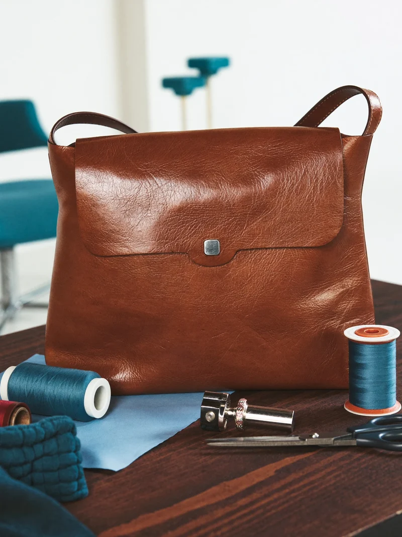 Illustration: Konzept der Reparatur einer Ledertasche